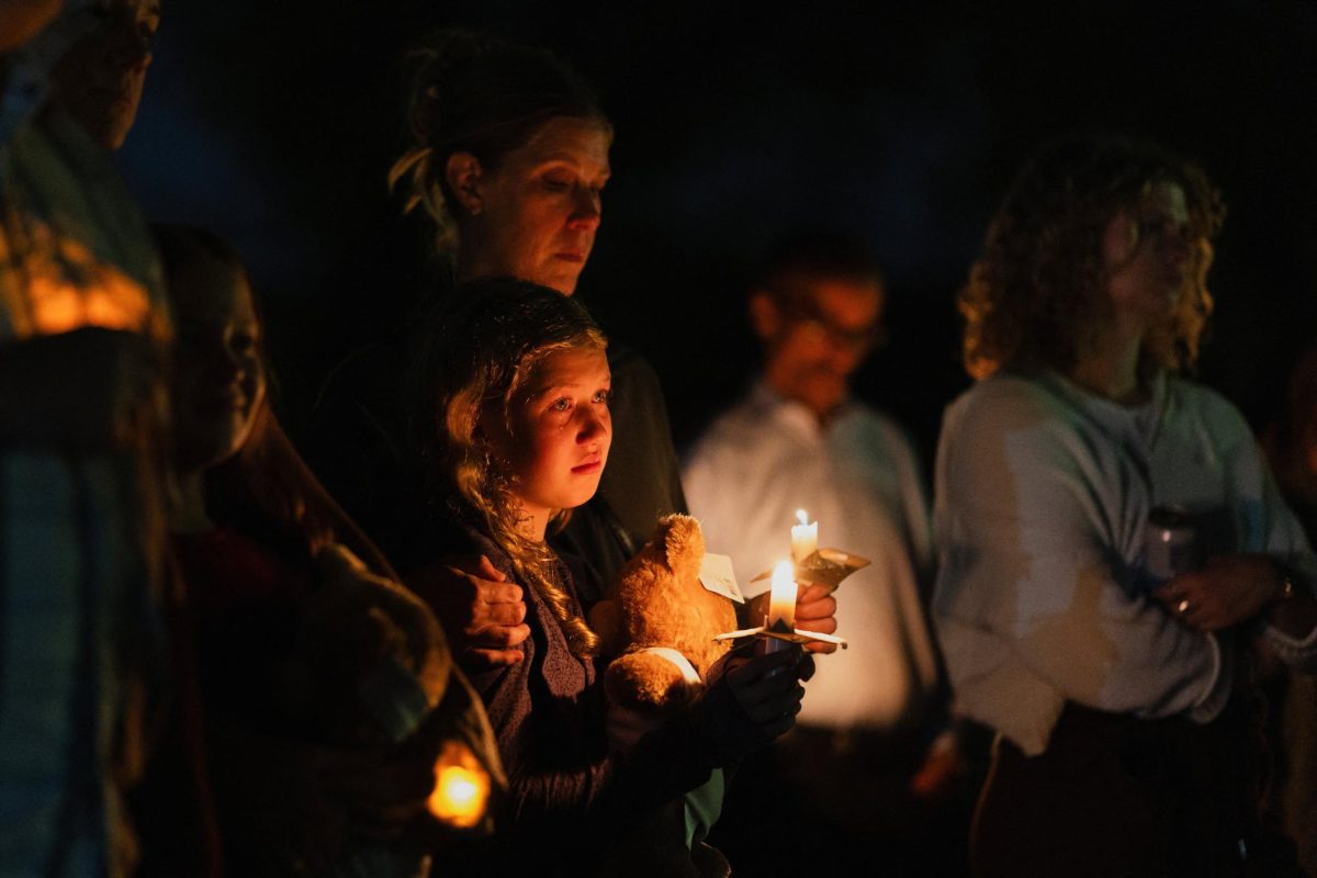 A tear falls down Linnea Opsahl’s cheek as she joins her mother Laura during a vigil at Lynnhurst Park following a shooting earlier in the day at Annunciation Church in Minneapolis, Minnesota, U.S. August 27, 2025.  REUTERS/Tim Evans