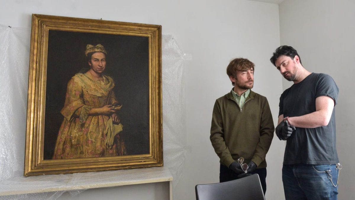 Visual arts teacher Ariel Bassano (L) stands next to a painting identified by Dutch newspaper AD as believed to be "Portrait of a Lady" by Italian baroque portraitist Giuseppe Ghislandi, stolen by the Nazis from a Dutch Jewish art collector, as it is displayed at the Public Prosecutor's Office in Mar del Plata, Argentina, on Sept. 3, 2025.(Stringer/AFP via Getty Images)