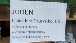 A photograph of an antisemitic sign on a shop window in Flensburg, Germany, went viral in September 2025. (Screenshot from social media)