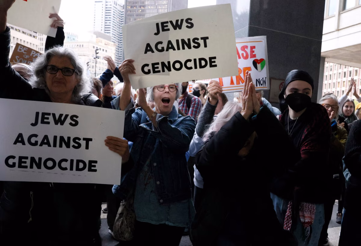 Protesters cheer as they rally outside of the John F. Kennedy Federal Building in support of six Jewish protesters who were stopped inside the hallway while trying to get to Sen. Elizabeth Warren's office where they had planned to stage a sit in and "call for U.S. action to prevent genocide in Gaza," Oct. 18. 2023. (Jessica Rinaldi/The Boston Globe via Getty Images)
