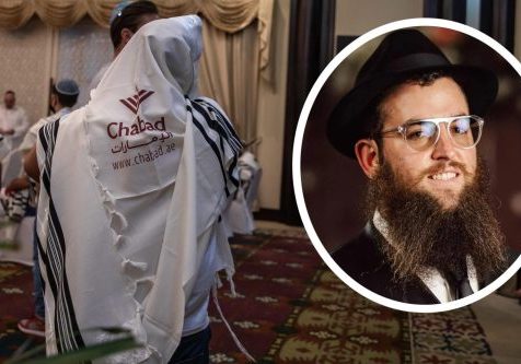 Rabbi Zvi Kogan is pictured in an undated photo distributed by Chabad. In background: The Jewish Community Center of the UAE hosts Yom Kippur prayers in Dubai, United Arab Emirates, Sept. 15, 2021 (Andrea DiCenzo/Getty Images)